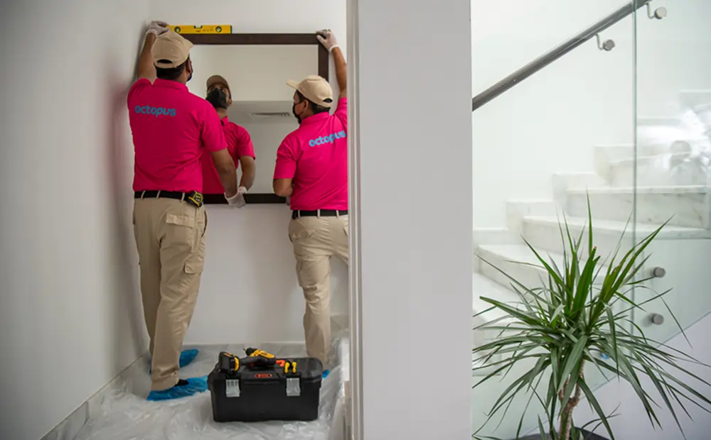Handyman Services In Dubai Octopus handyman installing a wall frame in a house in Dubai