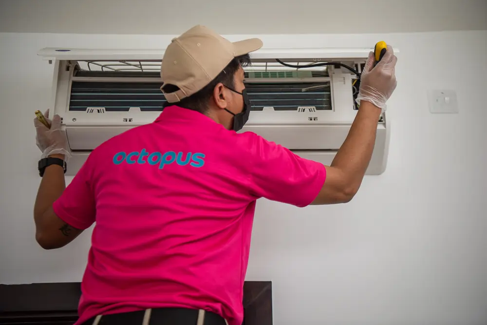 Ac Maintenance Services In Dubai Octopus Home Maintenance Technician Repairing an AC in Dubai